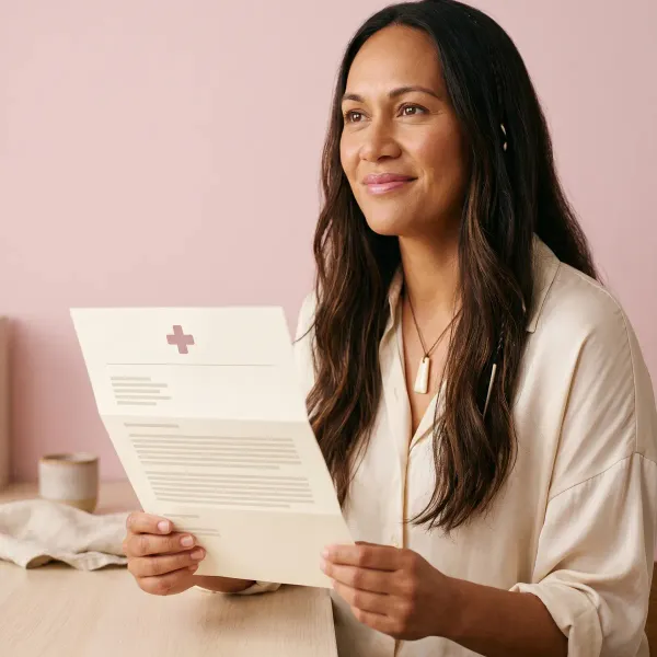 Woman reading a referral letter on her phone while relaxing at home